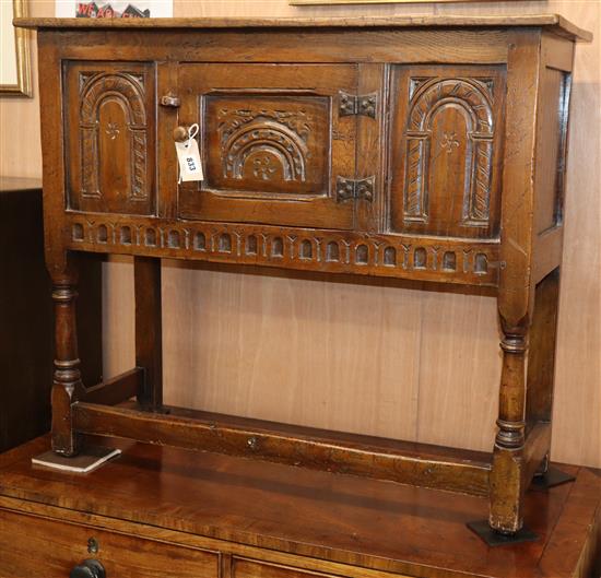 A reproduction carved oak small low cupboard W.92cm